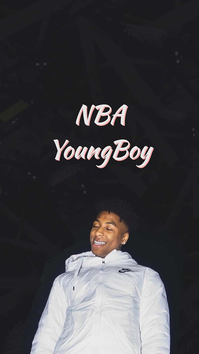 Youngboy 桌布 壁紙 — 一個微笑的年輕男子穿著白色外套，背景是深色抽象圖案，帶有發光文字NBA YoungBoy。