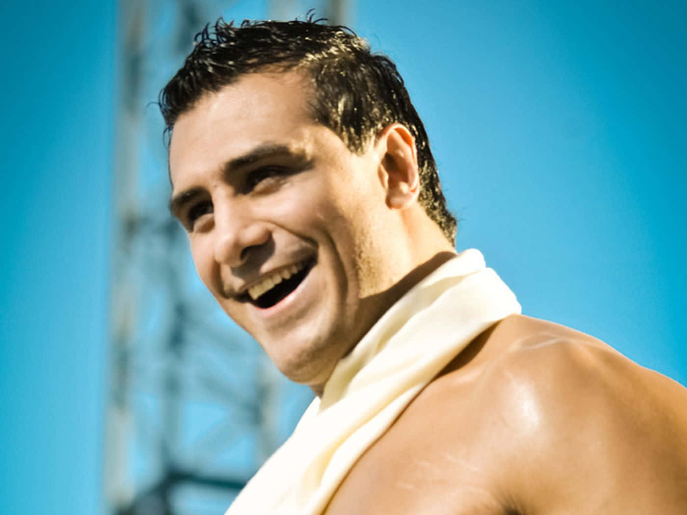 WWE 桌布 壁紙 — 一個微笑的男人，濕髮，脖子上掛著毛巾，在明亮的藍天下大笑。