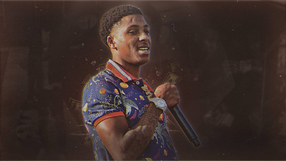 Youngboy 桌布 壁紙 — 一個微笑的男人穿著彩色圖案襯衫，拿著麥克風，錢在他周圍漂浮，舞台燈光昏暗。