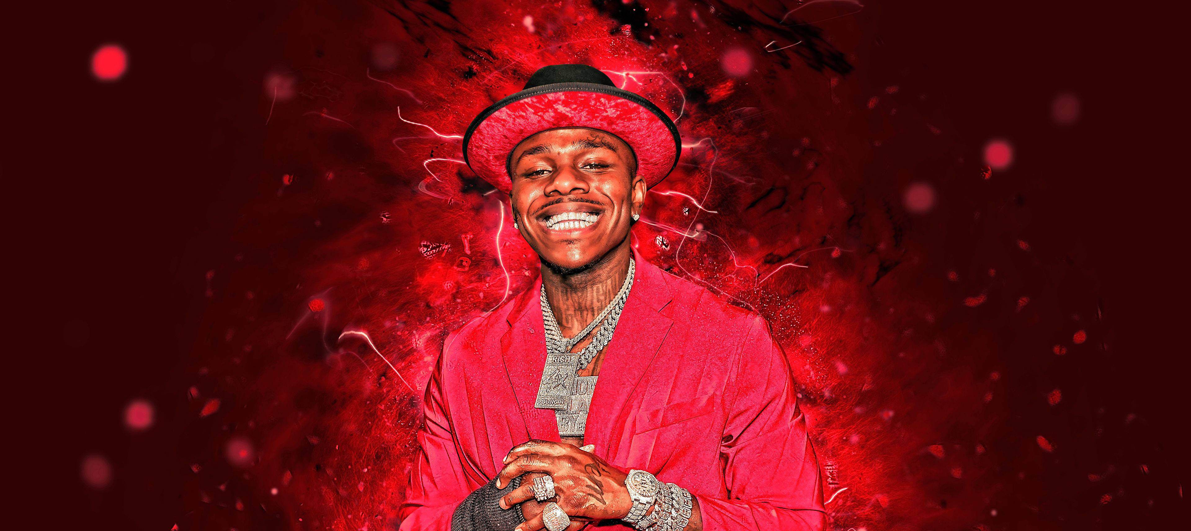 Dababy 桌布 壁紙 — 一個微笑的男人穿著紅色西裝和帽子，在充滿活力的紅色爆炸背景中散發能量，帶有發光粒子。