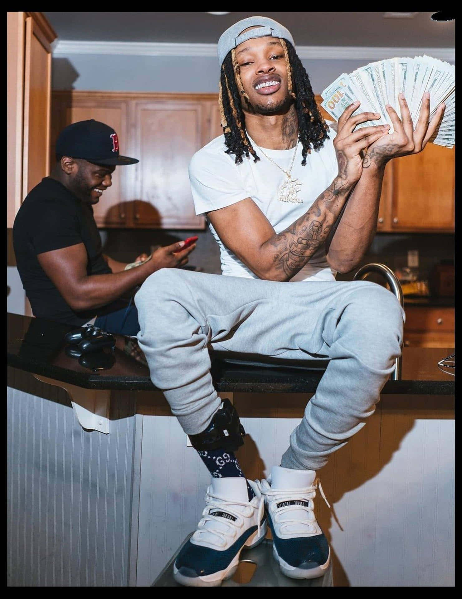 廚房裡兩個男人，一個拿著現金，另一個在笑 — King Von 壁紙