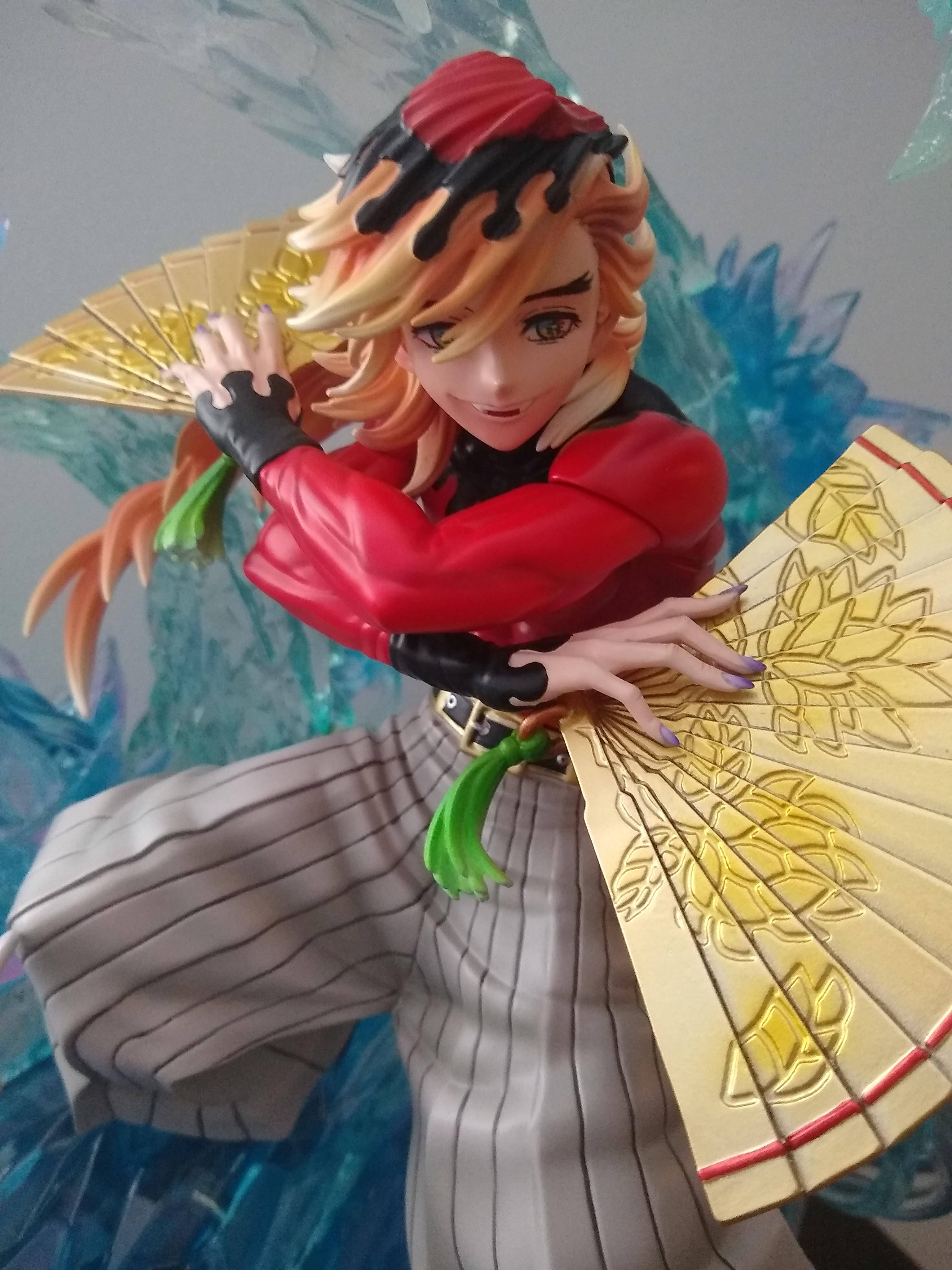 童磨 桌布 壁紙 — 一個微笑角色的動漫人偶，橙色頭髮、紅色服裝，在藍色水晶背景下手持華麗金色扇子。