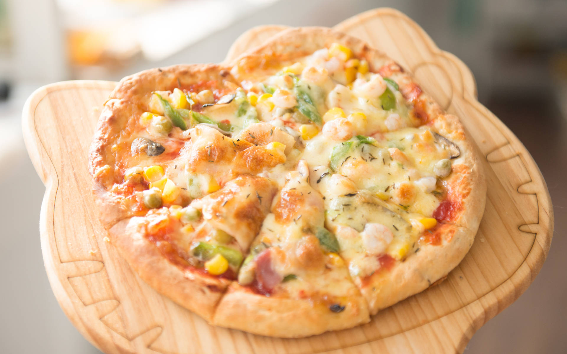 Pizza 桌布 壁紙 — 一個心形披薩，上面鋪滿蝦仁、玉米和香草，放在一個雕刻木製托盤上。