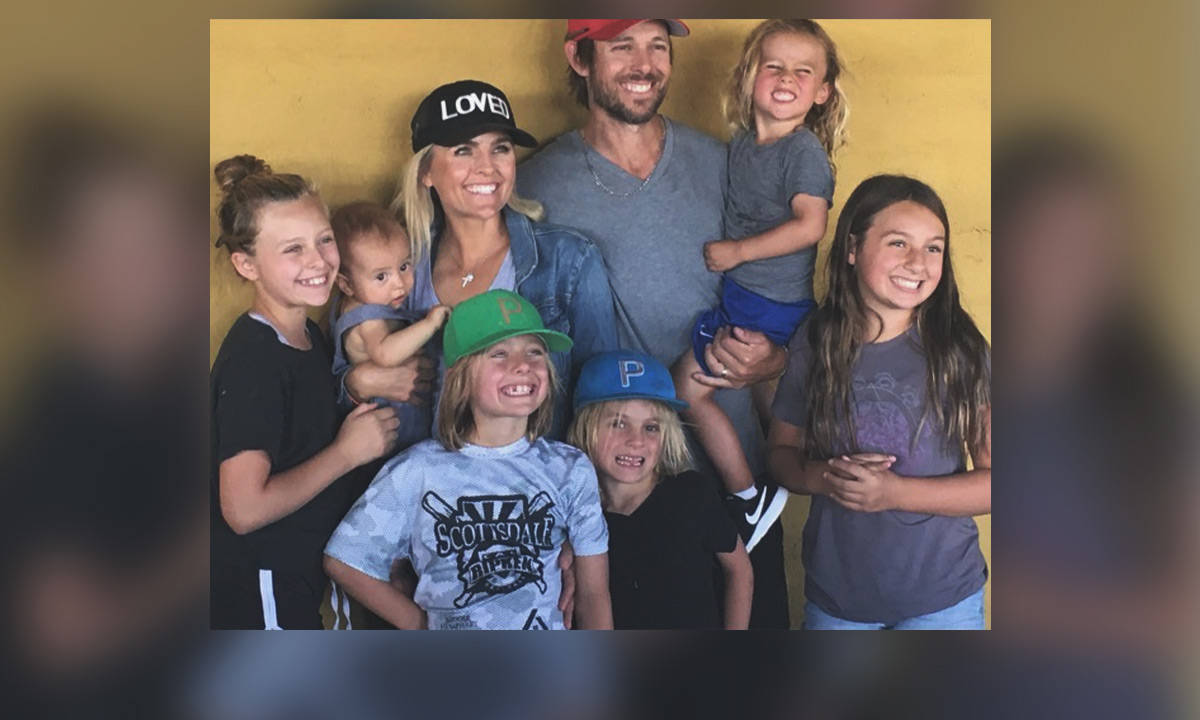 Family 桌布 壁紙 — 一個快樂的七人家庭在溫暖的黃色牆前一起擺姿勢，露出燦爛的笑容，穿著休閒服裝。