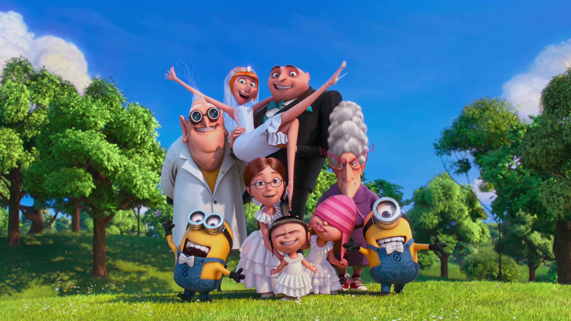 Despicable Me 2 桌布 壁紙 — 一個快樂的動畫小小兵與人類家庭，在陽光明媚的草地上，周圍是茂密的綠樹，開心地擺姿勢。