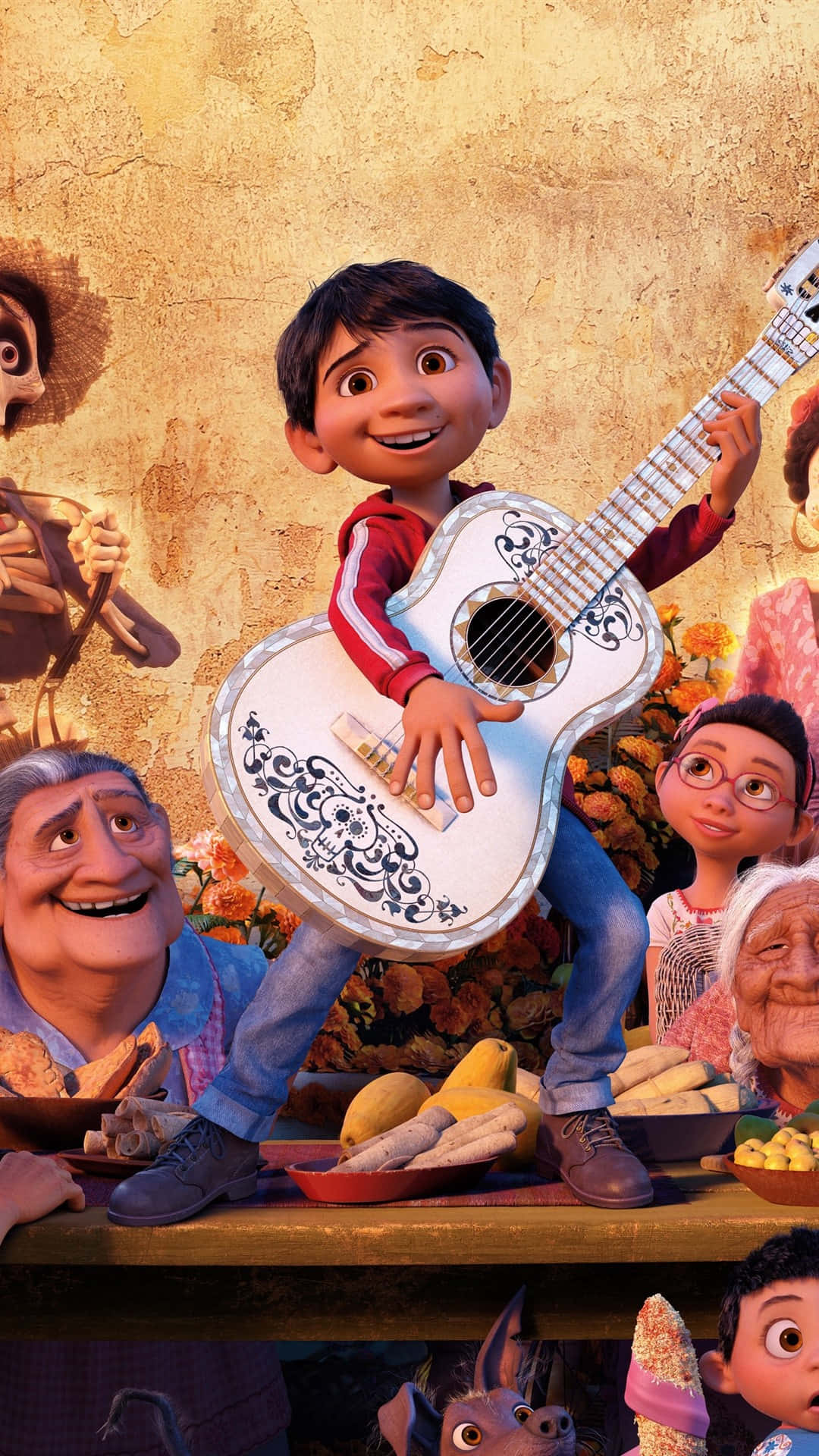 Coco Disney 桌布 壁紙 — 一個快樂的動畫男孩在紋理金色牆壁前，被微笑的家人和鮮豔的萬壽菊包圍，彈奏著裝飾過的吉他。