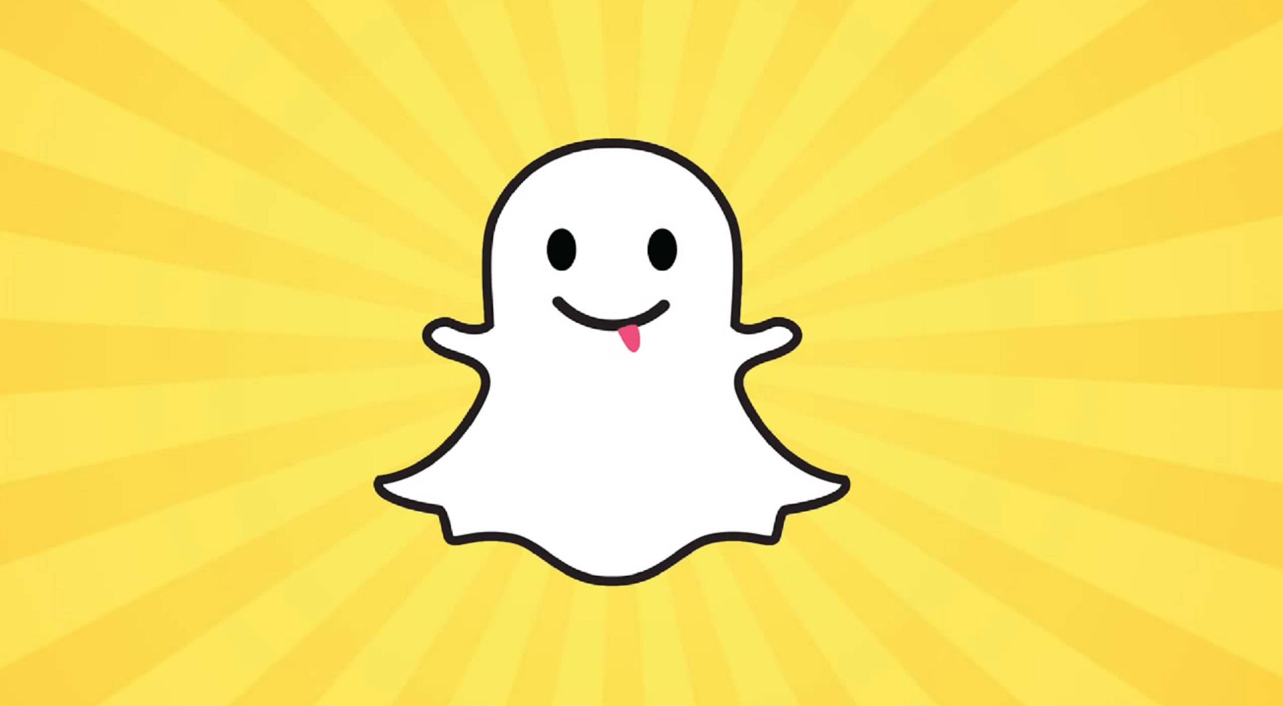 Snapchat 桌布 壁紙 — 一個快樂的卡通鬼魂伸出粉紅色舌頭，在明亮的黃色太陽光背景下突出。