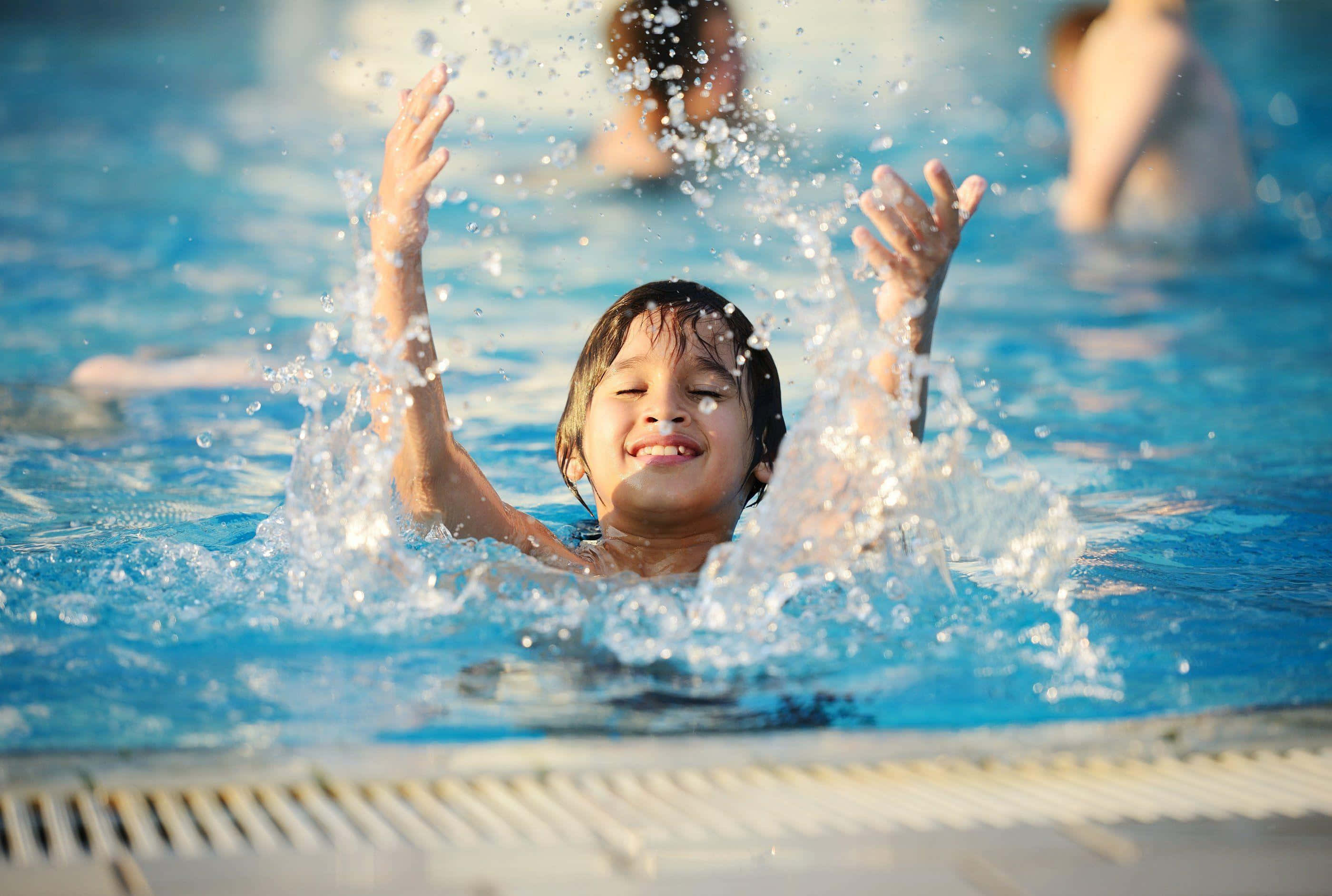 Swimming 桌布 壁紙 — 一個快樂的孩子在溫暖陽光下，於明亮的藍色泳池中舉起雙臂潑水。