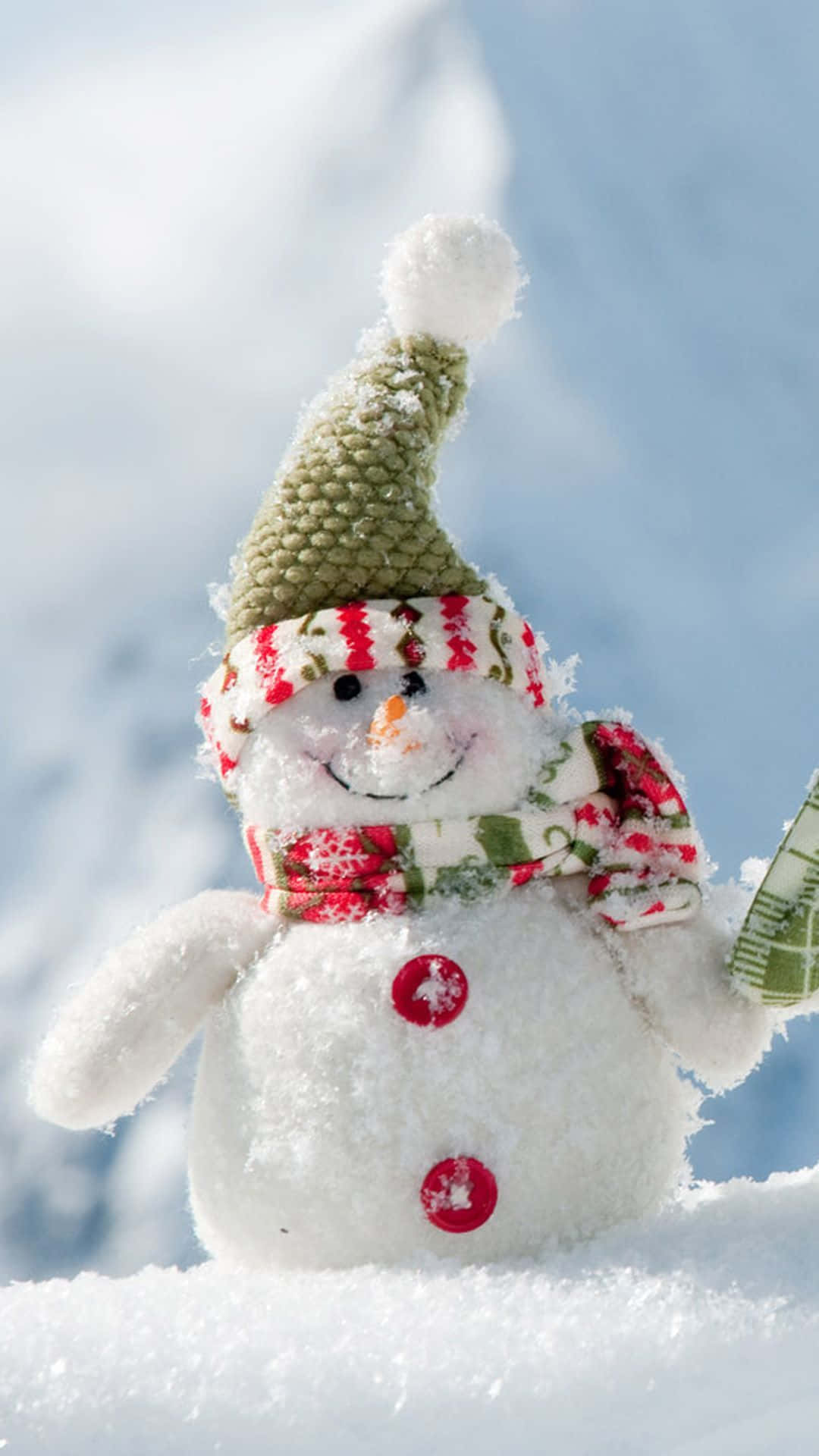 Christmas Snowman 桌布 壁紙 — 一個快樂的手工雪人，戴著綠色針織帽和紅色鈕扣眼睛，站在明亮的冬日陽光下。