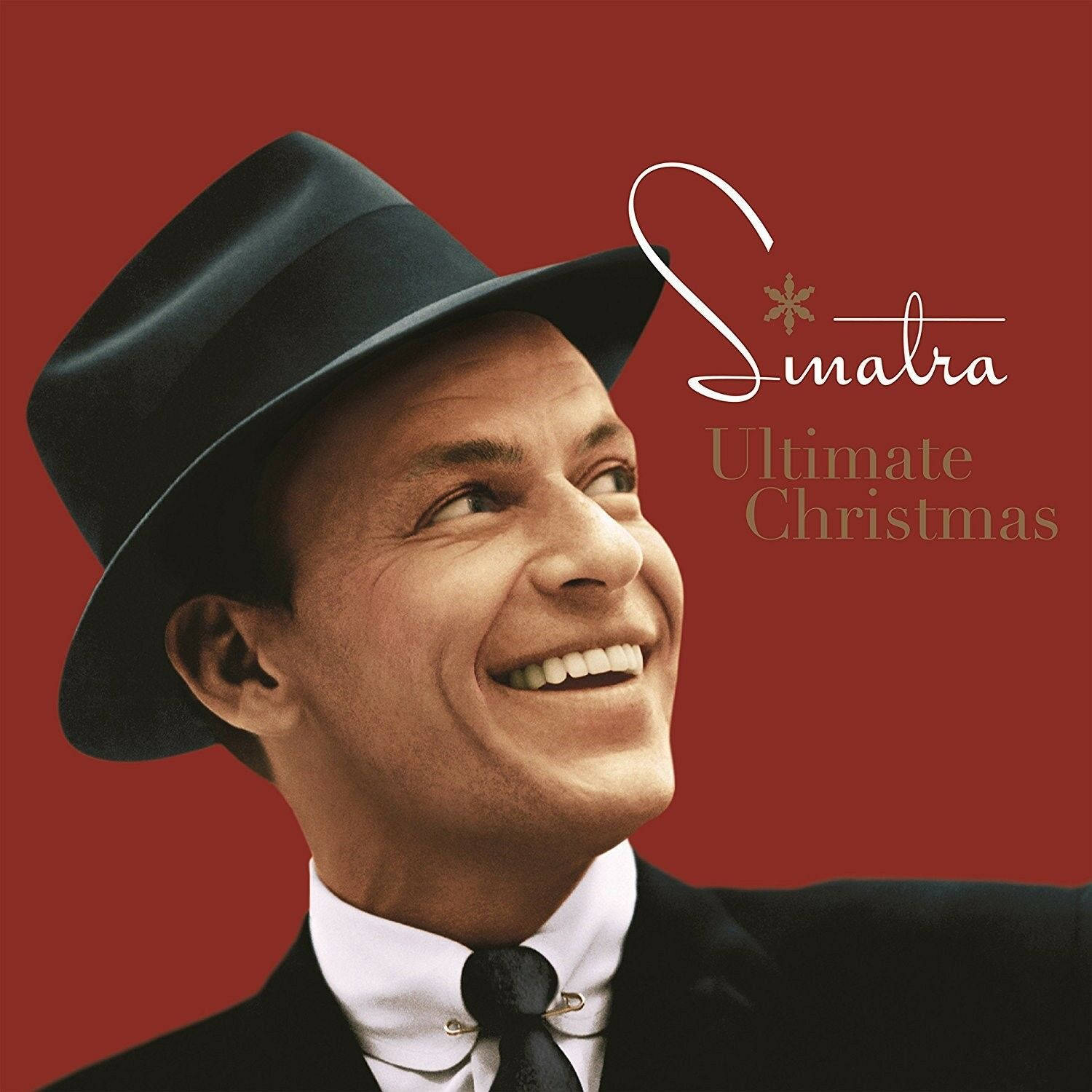 Sinatra 桌布 壁紙 — 一個快樂的法蘭克·辛納屈，戴著黑色軟呢帽、穿著西裝，在豐富的紅色背景上向上微笑，並帶有優雅的草書文字。