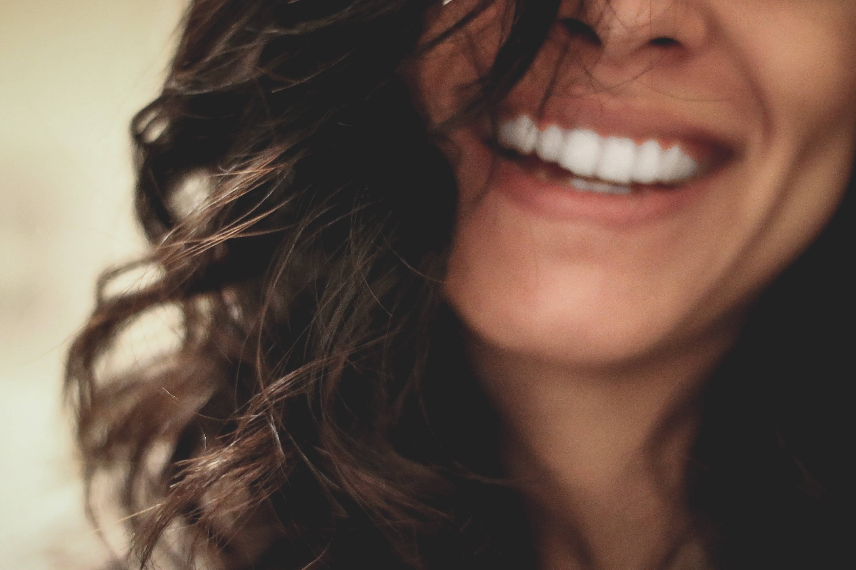 Smile 桌布 壁紙 — 一個快樂的特寫，女人的微笑嘴巴，深色波浪頭髮框住她明亮的白色牙齒。