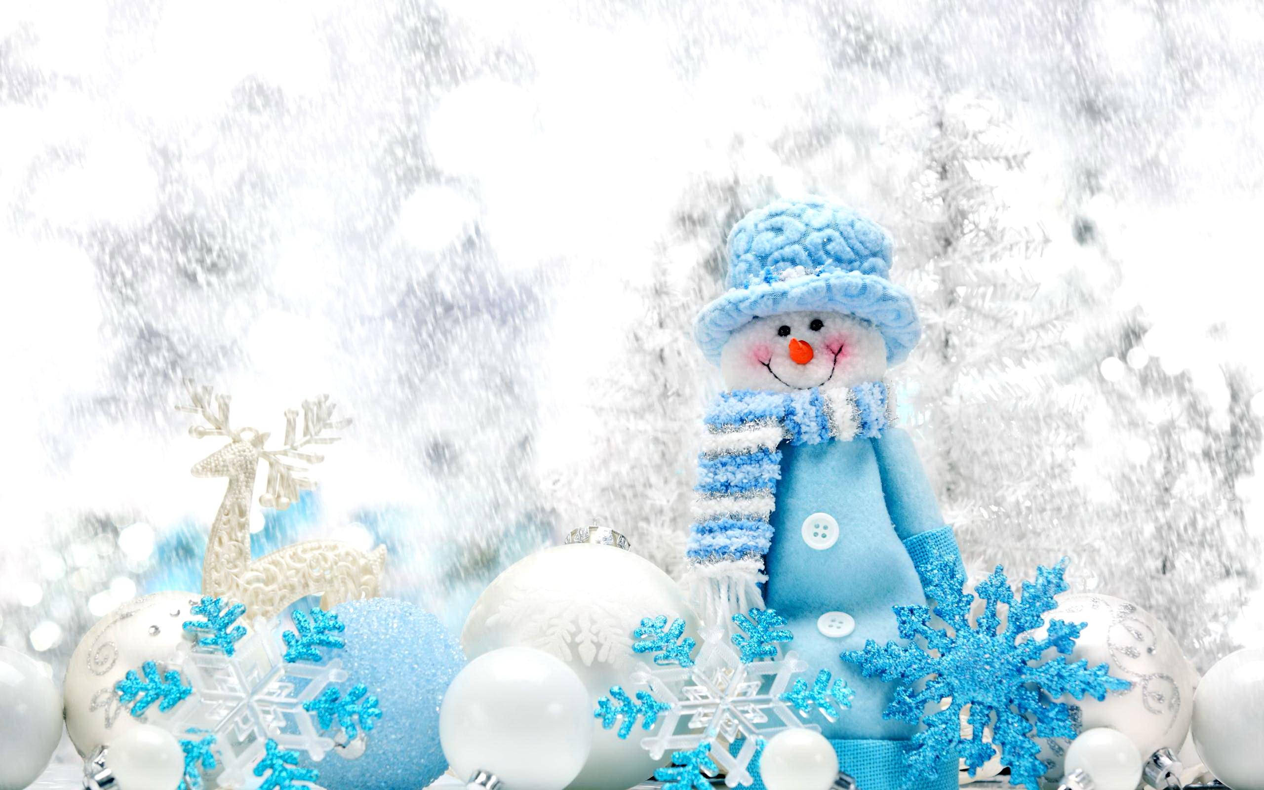 雪人 桌布 壁紙 — 一個快樂的藍色雪人戴著針織帽和圍巾，站在閃爍的雪花和節日裝飾之間，背景是雪地。