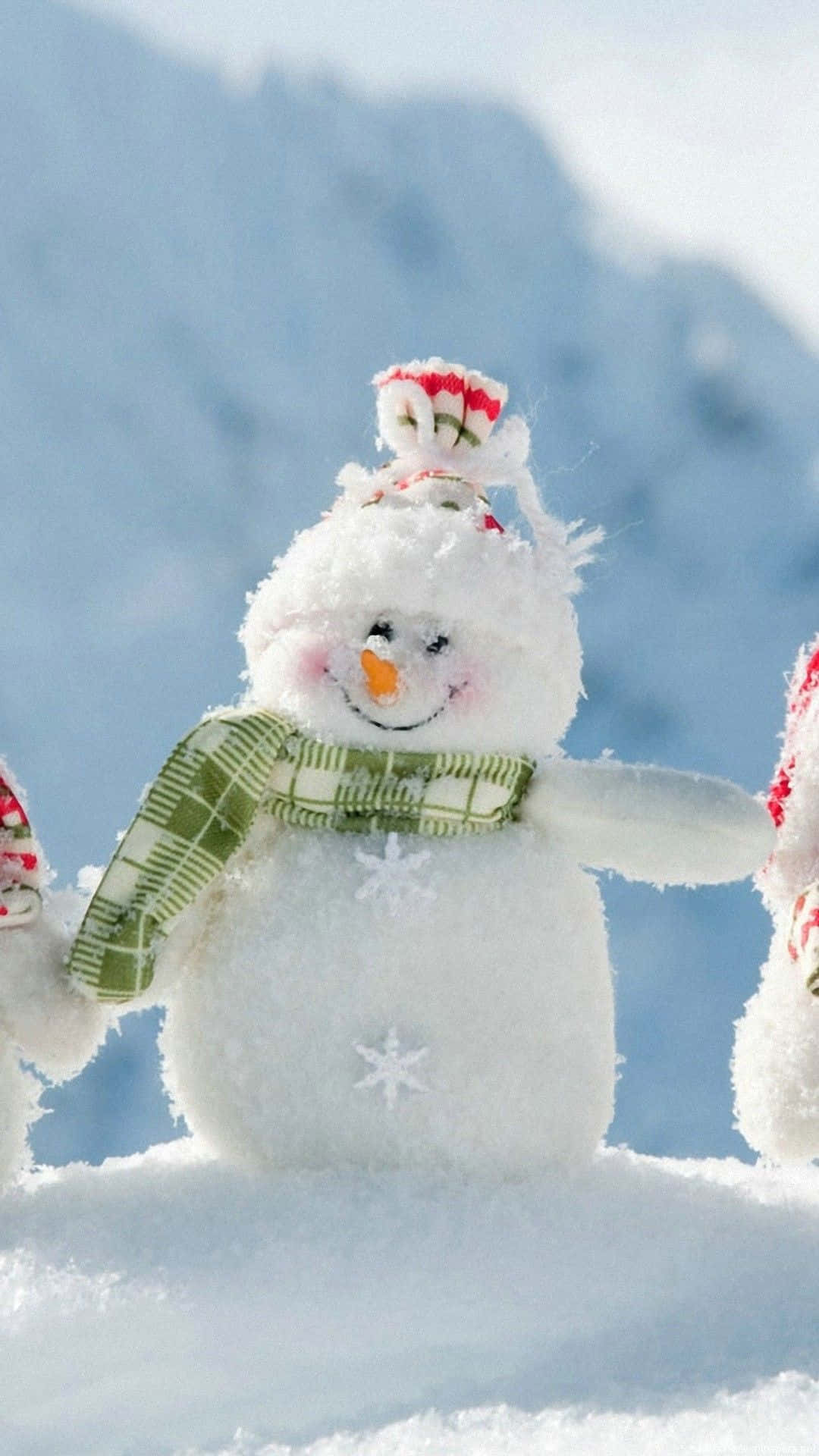 雪人 桌布 壁紙 — 一個快樂的雪人，戴著綠色格紋圍巾和胡蘿蔔鼻子，站在明亮的雪地冬季景觀中。