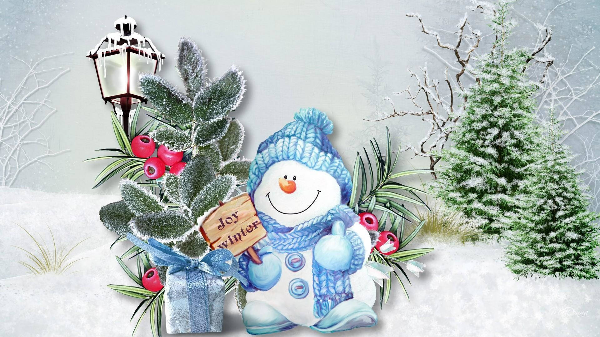 Joy 桌布 壁紙 — 一個快樂的雪人戴著藍色針織帽和圍巾，站在結霜的松枝旁，松枝上有紅色漿果和一個禮物盒，在雪白的冬日場景中。