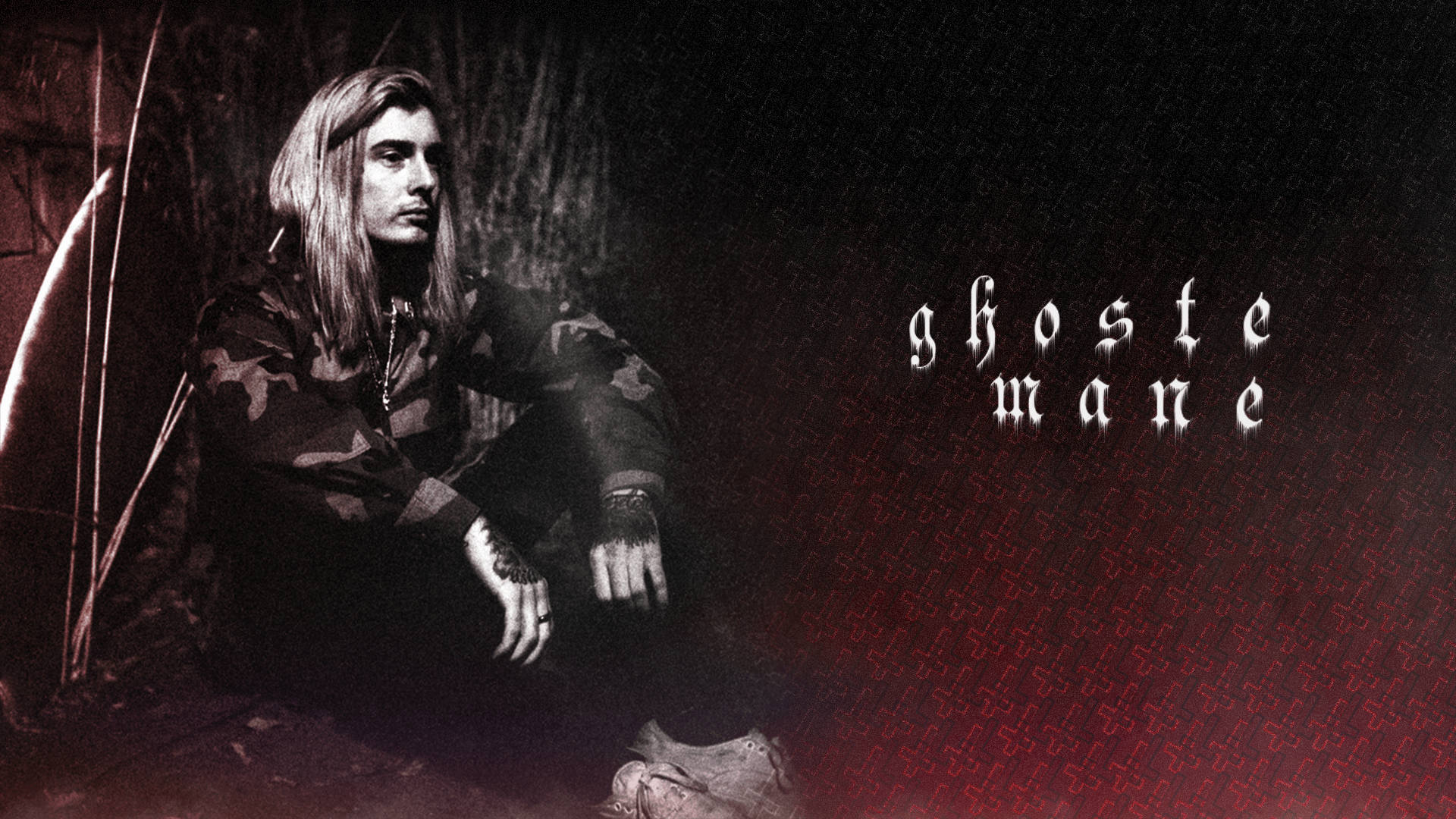 Ghostemane 桌布 壁紙 — 一個情緒化的肖像，一個長髮男子穿著迷彩服坐在深色紋理牆壁前，牆上有紅色發光文字寫著 ghost mane。