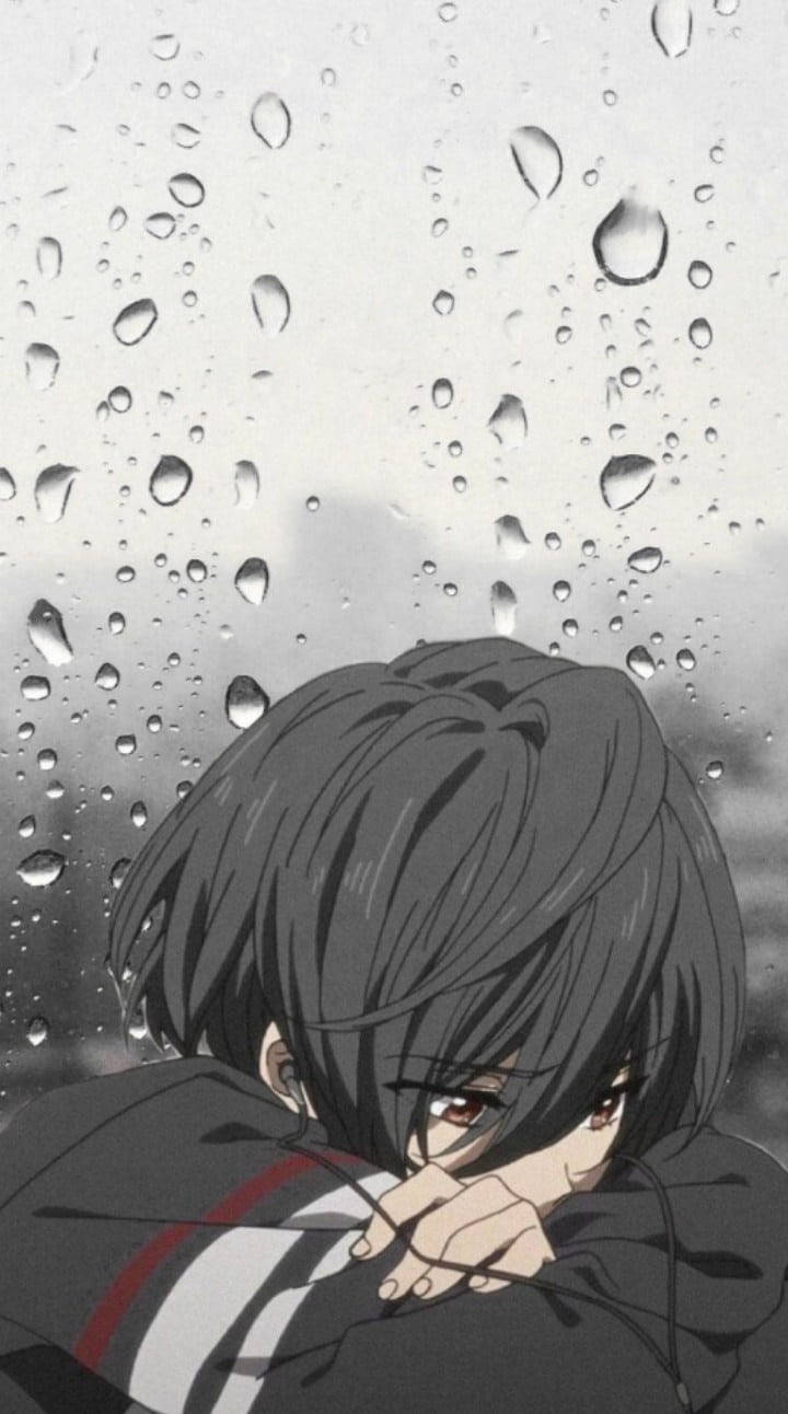 憂鬱少年動漫 桌布 壁紙 — 一個憂鬱的動漫男孩，深色頭髮，頭枕在手臂上，凝視著佈滿雨點的窗戶。