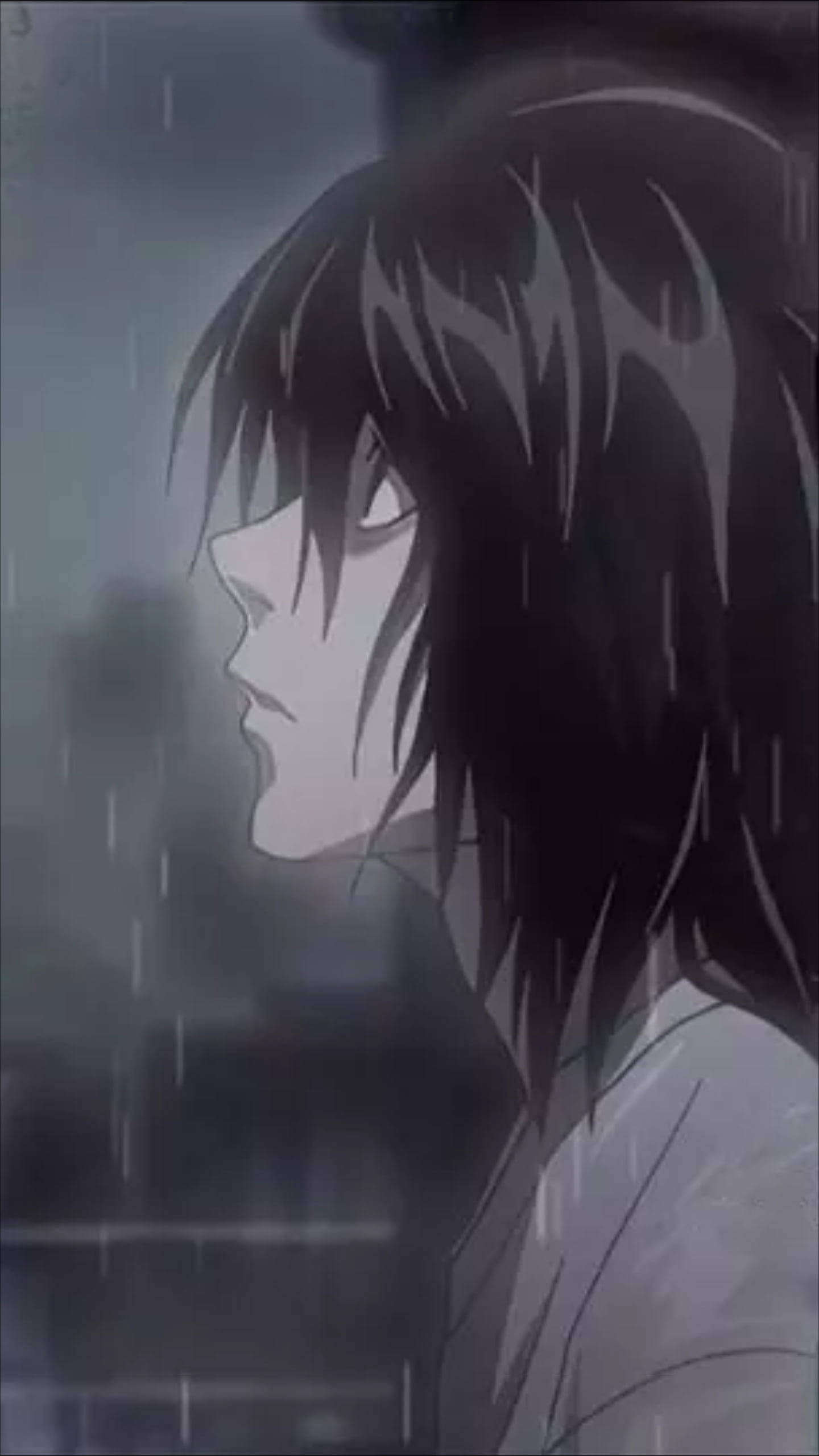 死亡筆記本 桌布 壁紙 — 一個憂鬱的動漫角色，深色頭髮，站在下雨的灰色城市場景中，雨滴在模糊的背景上劃出條紋。