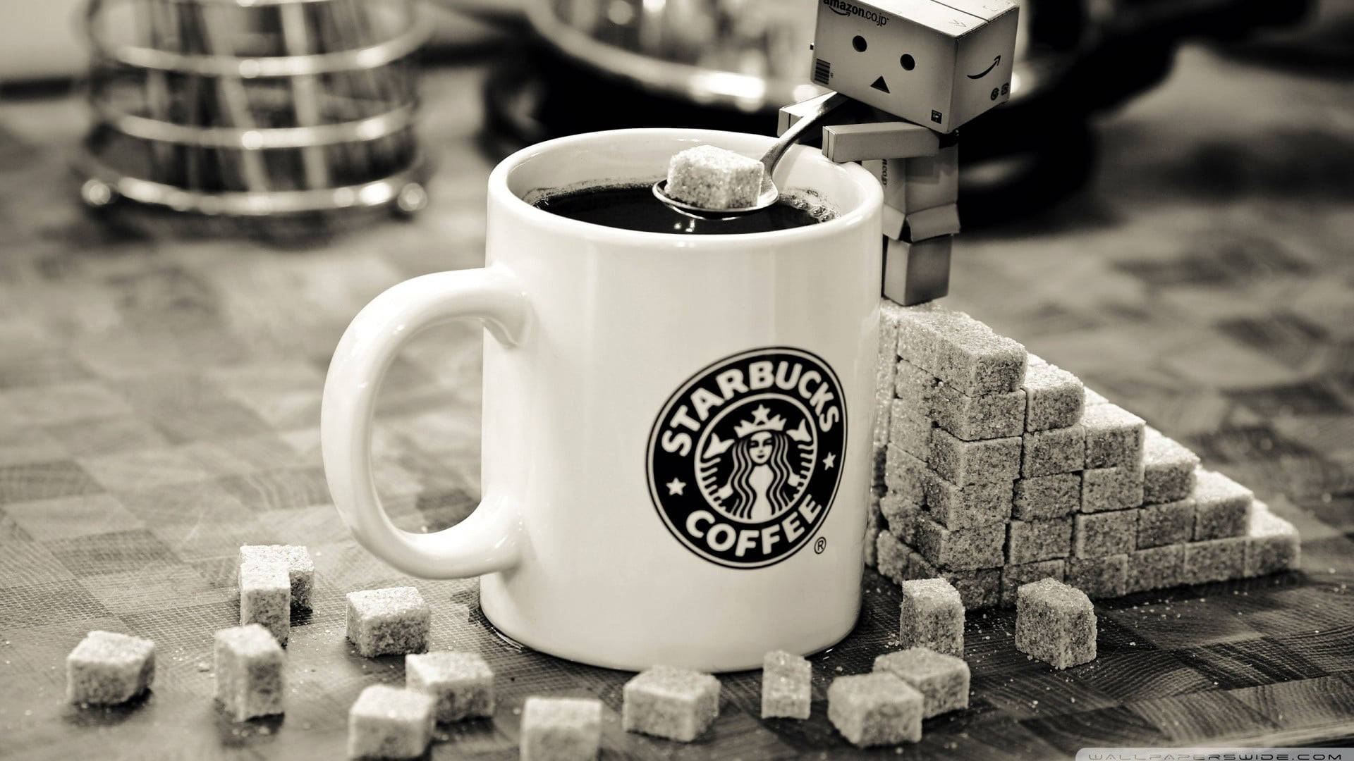 星巴克 桌布 壁紙 — 一個懷舊色調的Starbucks咖啡杯，旁邊有方糖和一個用湯匙加糖的小機器人。