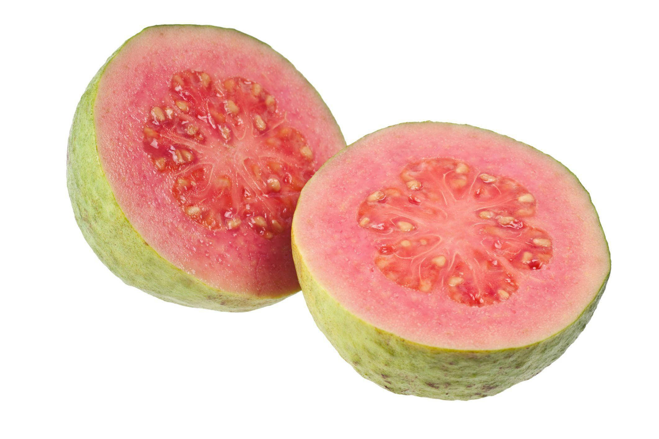 Fruit 桌布 壁紙 — 一個成熟的粉紅色果肉芭樂，綠色外皮，切開兩半，放在白色背景上。