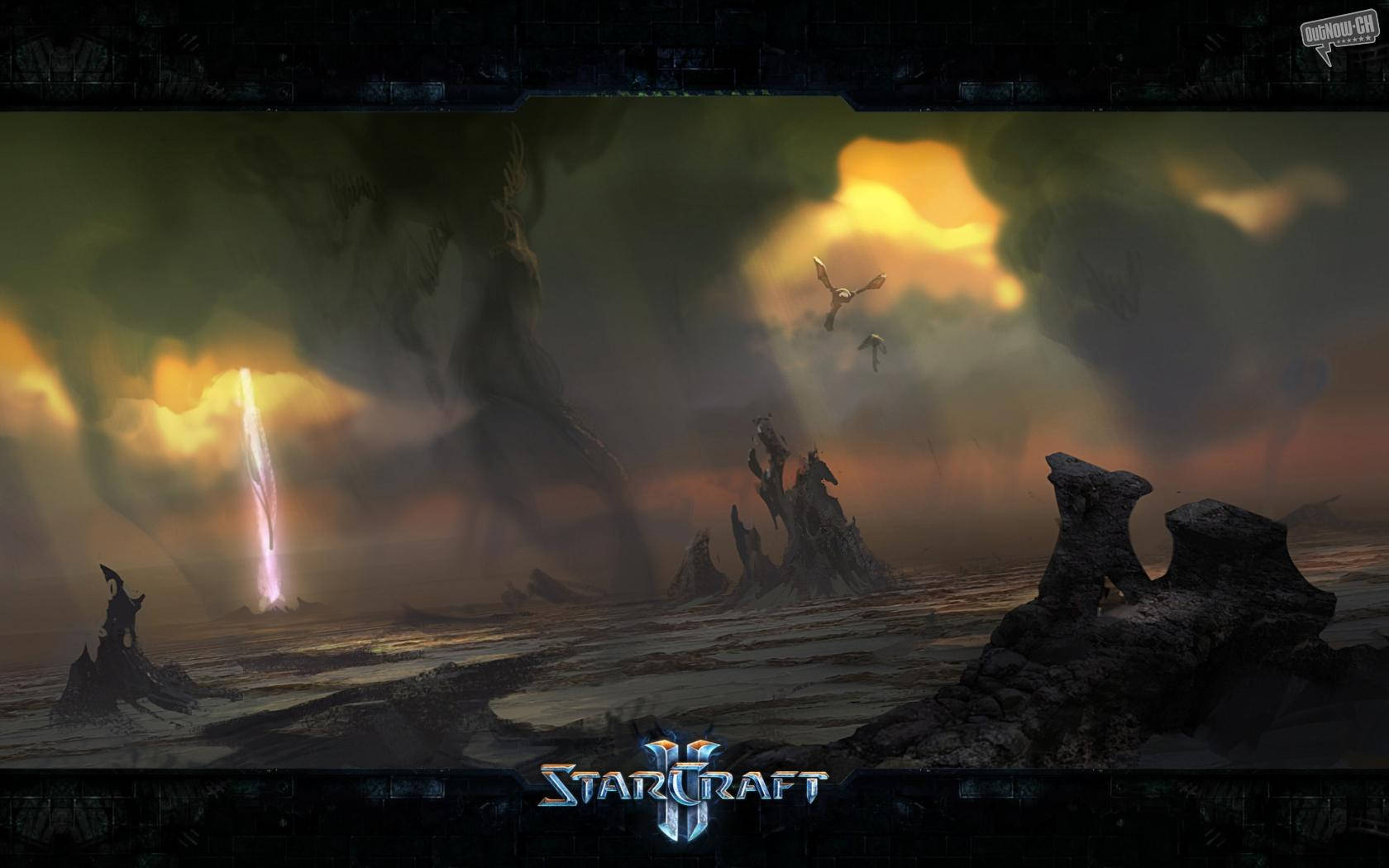 Starcraft 桌布 壁紙 — 一個戲劇性的外星景觀，有鋸齒狀的岩石形成和一道發光的光束刺穿暴風雨的天空，而飛行生物在頭頂翱翔。