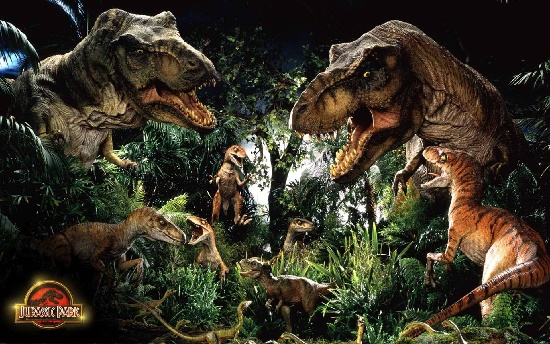 Jurassic World 桌布 壁紙 — 一個戲劇性的夜晚場景，多隻恐龍包括暴龍和迅猛龍在茂密的叢林樹葉中潛行。