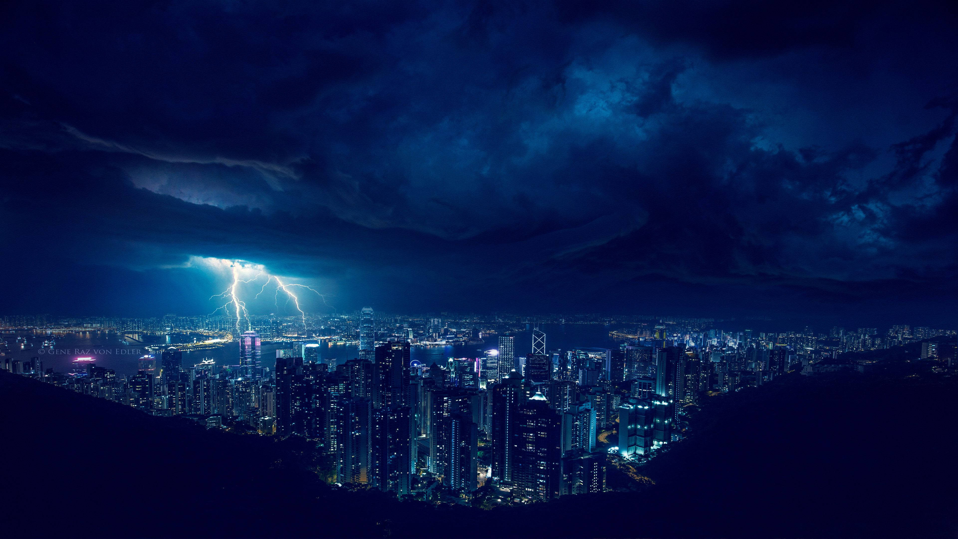 閃電 桌布 壁紙 — 一個戲劇性的夜景城市景觀，被生動的閃電照亮，劃過密集的城市天際線。