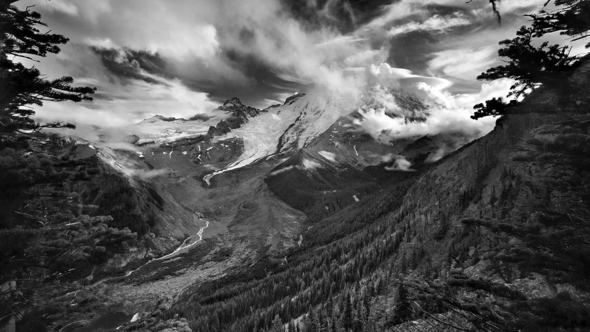 Cool Black And White 桌布 壁紙 — 一個戲劇性的黑白山景，有白雪覆蓋的山峰、旋轉的雲霧，以及蜿蜒穿過森林山谷的河流。