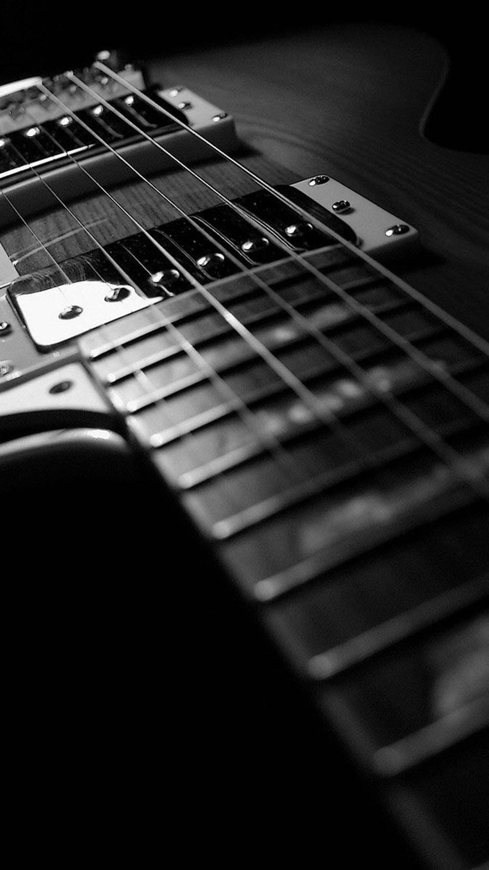 Guitar Aesthetic 桌布 壁紙 — 一個戲劇性的黑白特寫，展示電吉他的琴頸和拾音器，景深較淺。