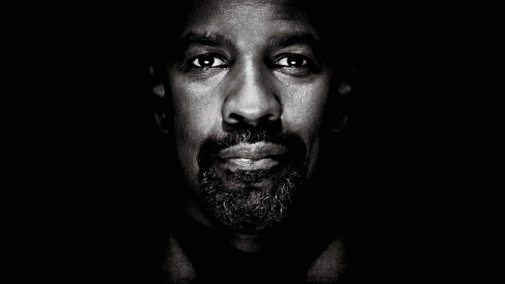 Denzel Washington 桌布 壁紙 — 一個戲劇性的黑白特寫肖像，一個留鬍子的男人在黑暗的背景前。