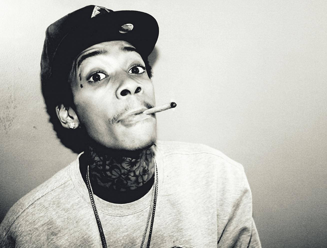 wiz khalifa 桌布 壁紙 — 一個戴帽子、叼著煙、脖子有刺青的男人，睜大眼睛向上看的黑白肖像。