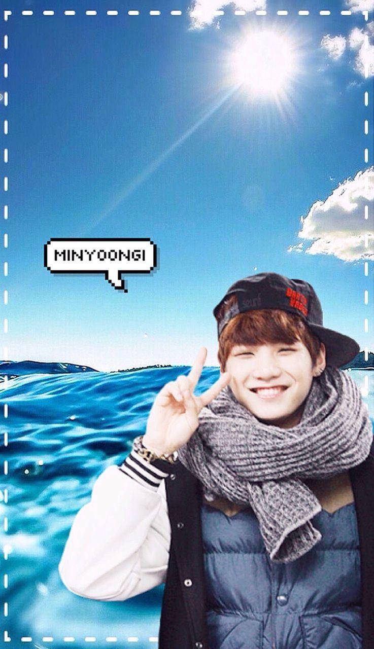 bts iPhone 桌布 壁紙 — 一個戴帽子和圍巾的微笑年輕男子在明亮的藍天和海洋背景下做出和平手勢，並有一個像素化的對話氣泡。