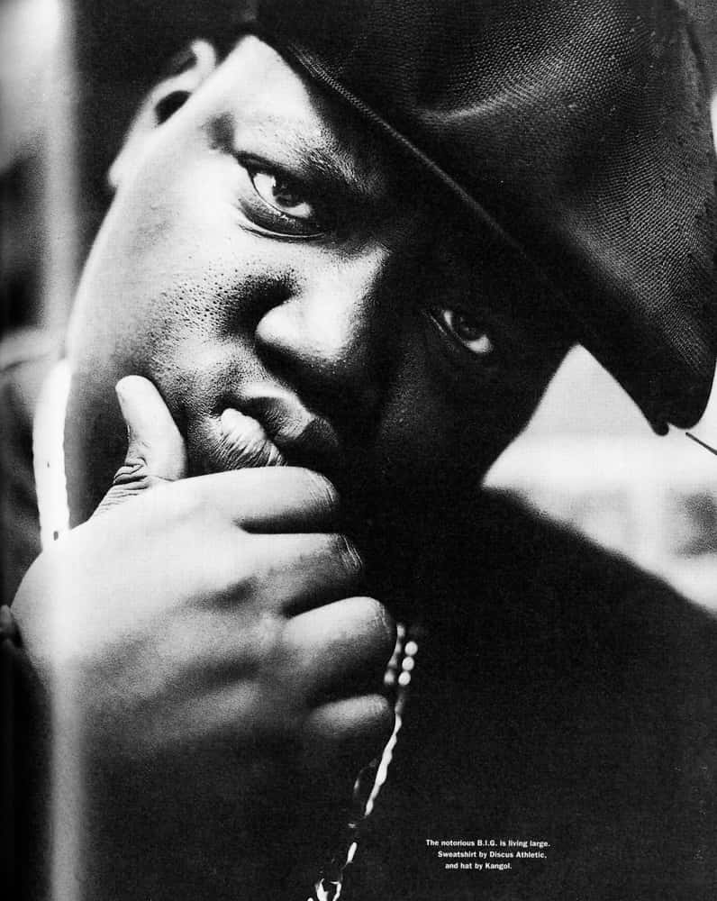hiphop 桌布 壁紙 — 一個戴帽男士的黑白近距離肖像，他將手放在嘴邊，專注地看著鏡頭。