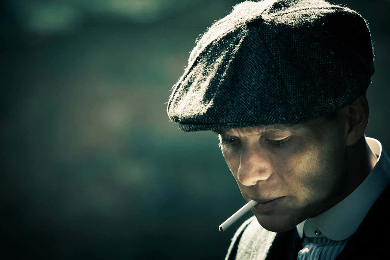 戴平頂帽的男人抽煙，表情嚴肅 — Peaky Blinders 壁紙