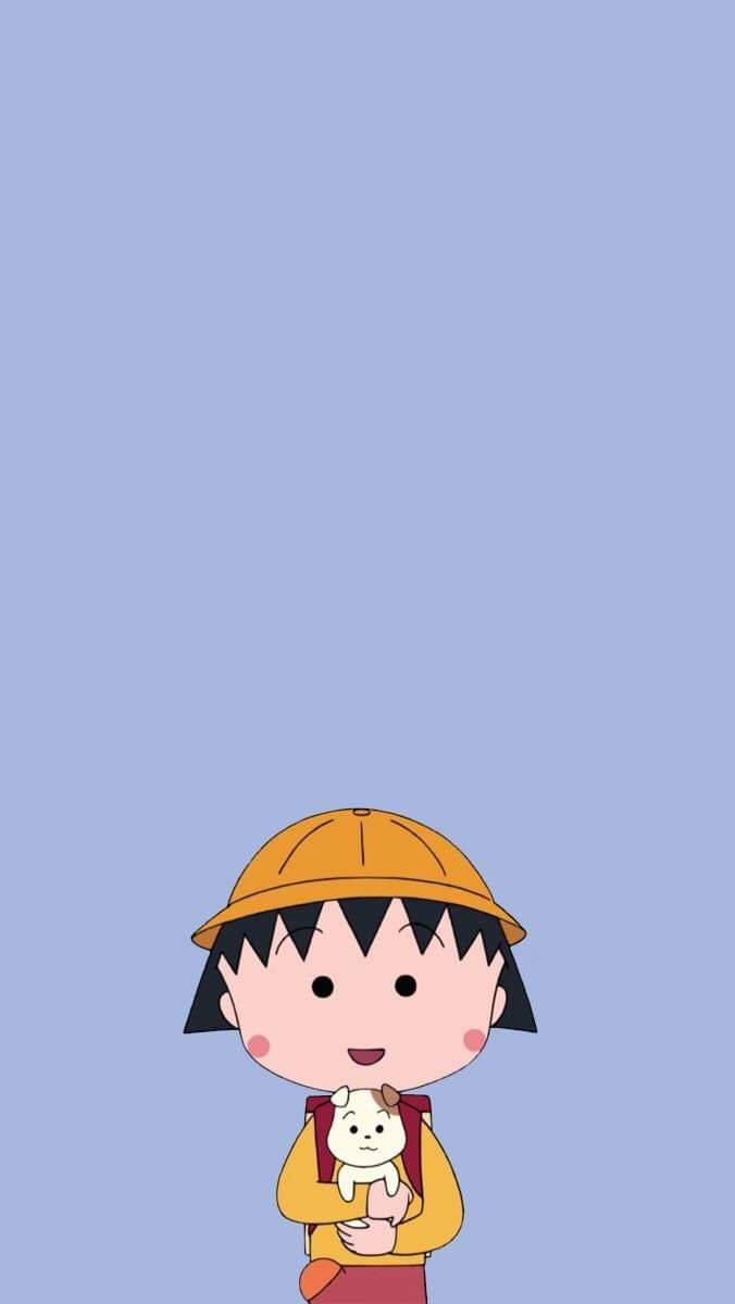 Chibi Maruko Chan 桌布 壁紙 — 一個戴橙色帽子、穿黃色外套的開心卡通女孩，在柔和的藍色背景前抱著一隻小白狗。