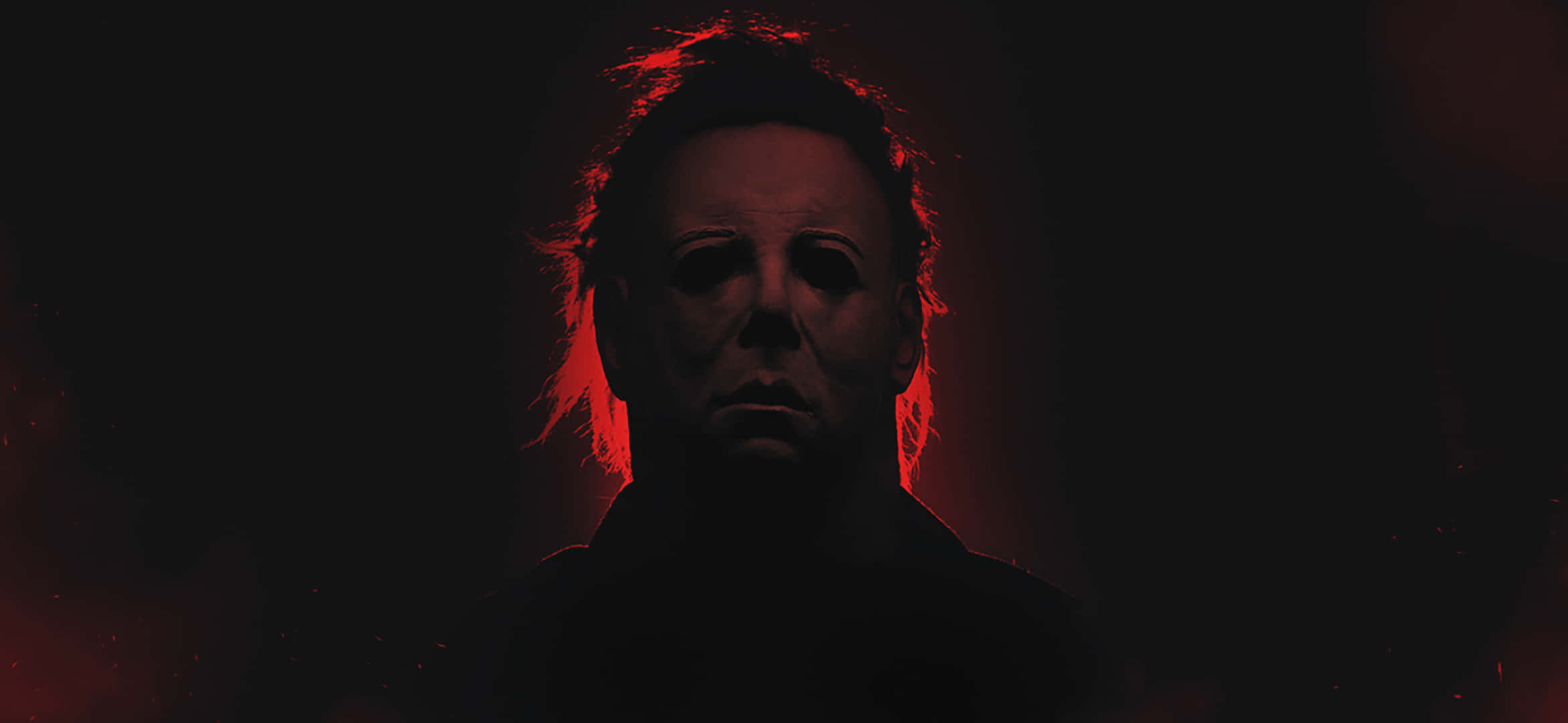 Halloween Michael Myers 桌布 壁紙 — 一個戴白色面具的威脅人物在黑暗背景中發出紅光。