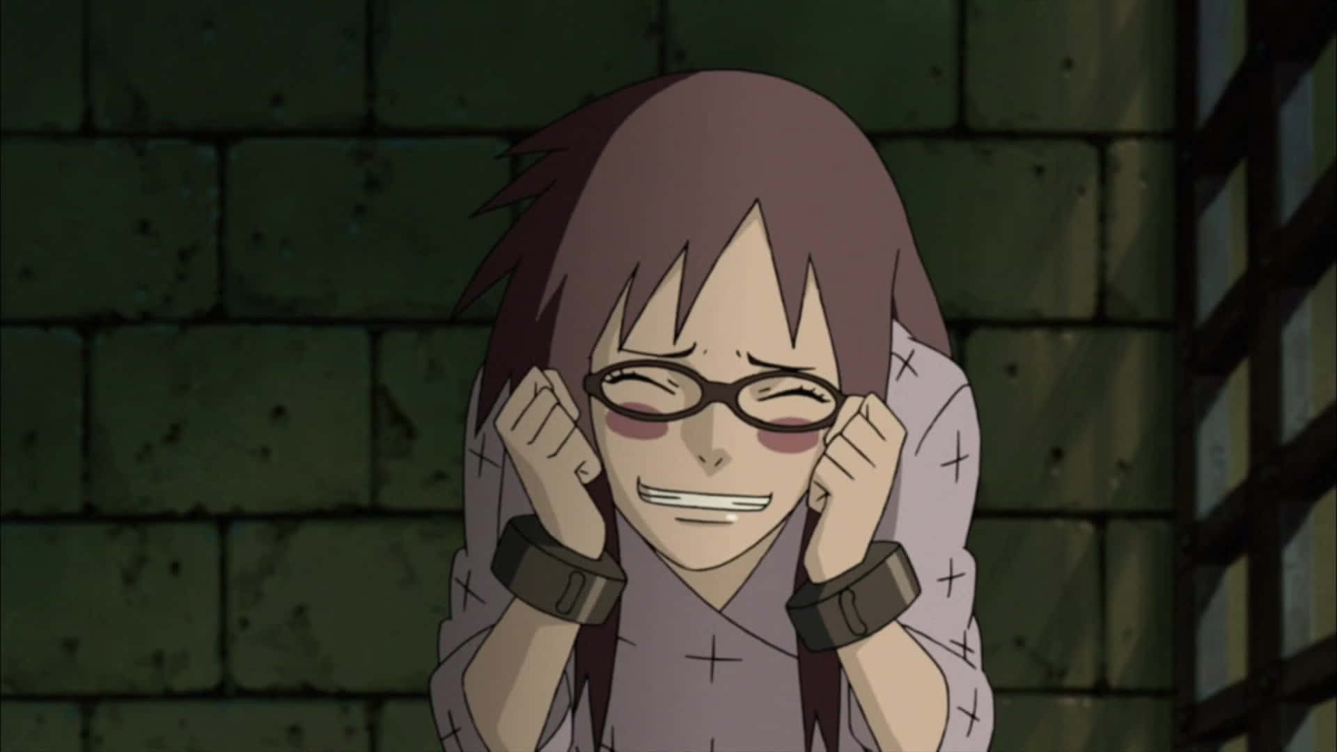 Karin Uzumaki 桌布 壁紙 — 一個戴眼鏡、棕色頭髮的動漫角色在昏暗的石牢中，調皮地微笑著，同時抓著自己的耳朵。