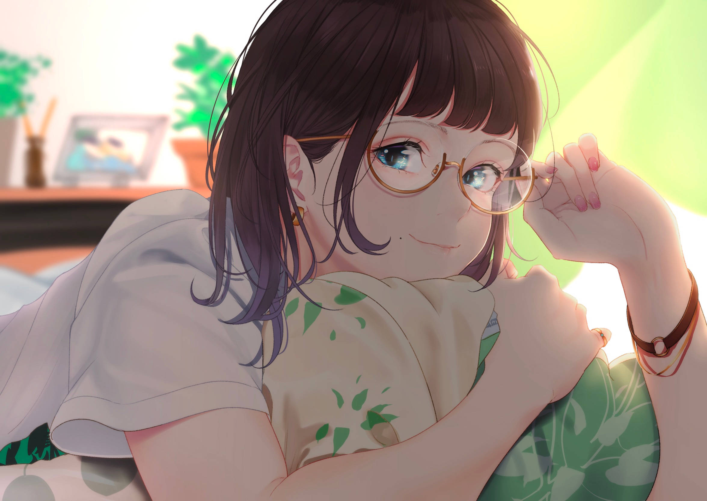 動漫女孩 桌布 壁紙 — 一個戴眼鏡、深色頭髮的開心動漫女孩，在陽光充足的房間裡，躺在綠色葉子圖案的枕頭上微笑。