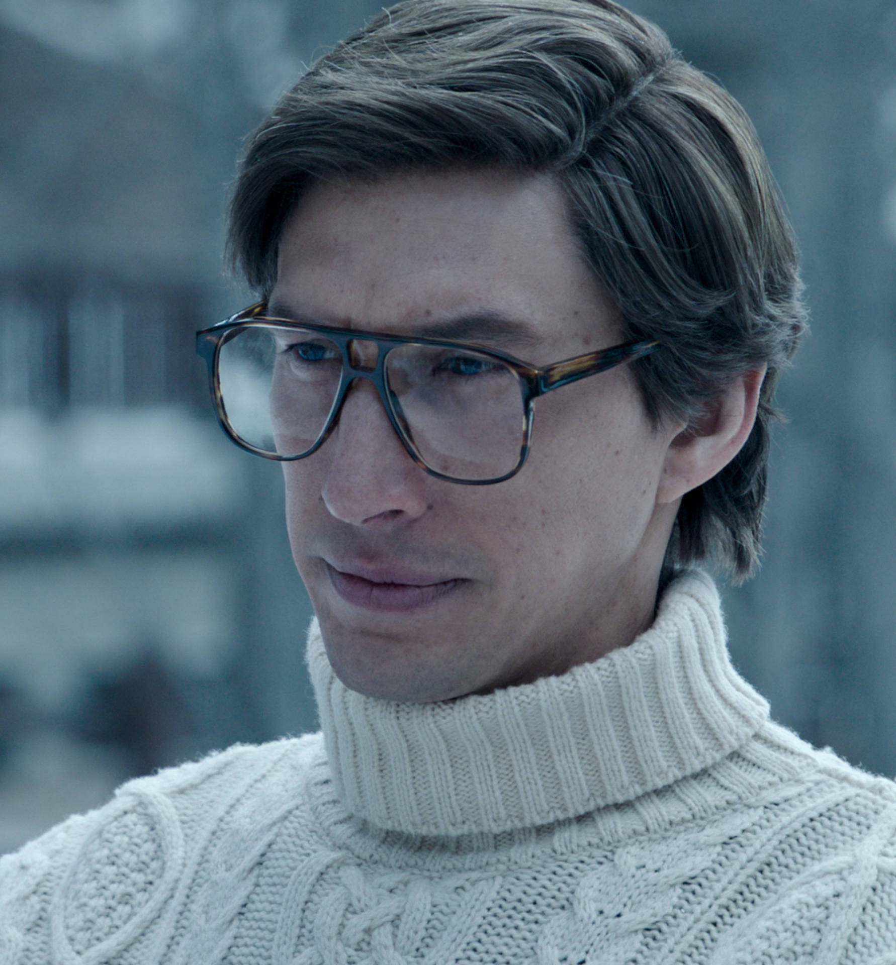 戴眼鏡、身穿奶油色高領毛衣的男人，在冬天若有所思地望向外面。 — Gucci 之家 壁紙