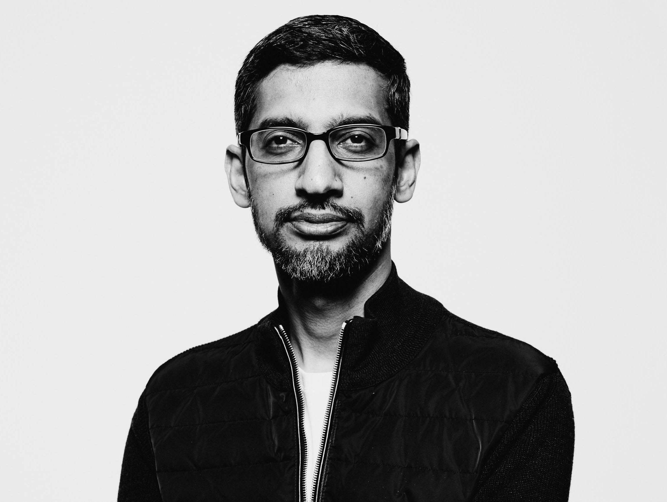 google 桌布 壁紙 — 一個戴眼鏡和鬍鬚的男人，身穿深色外套，在純色背景前的黑白肖像。