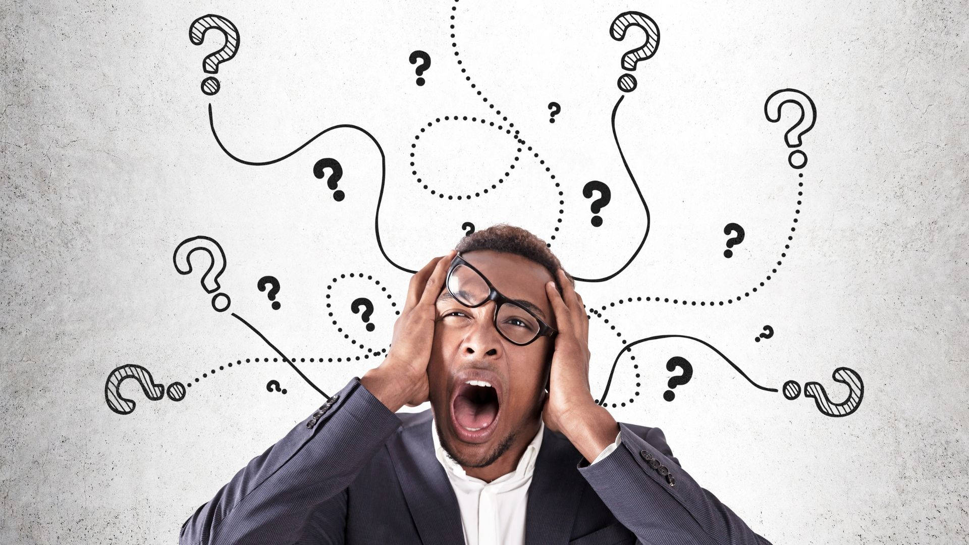 Questions 桌布 壁紙 — 一個戴眼鏡的壓力大商人尖叫著抱住頭，旋轉的問號在他周圍爆炸。