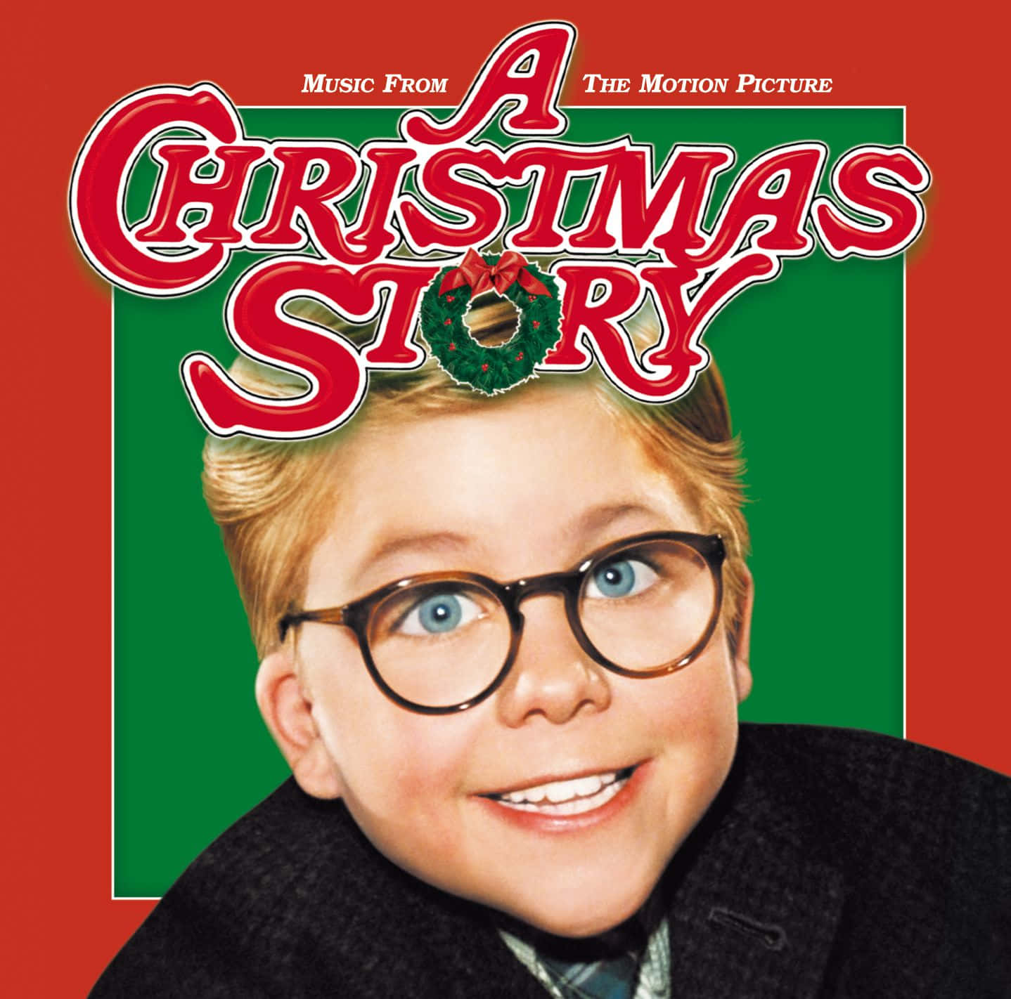 a christmas story 桌布 壁紙 — 一個戴眼鏡的開朗小男孩，在帶有電影標題的節日紅綠背景前燦爛微笑。
