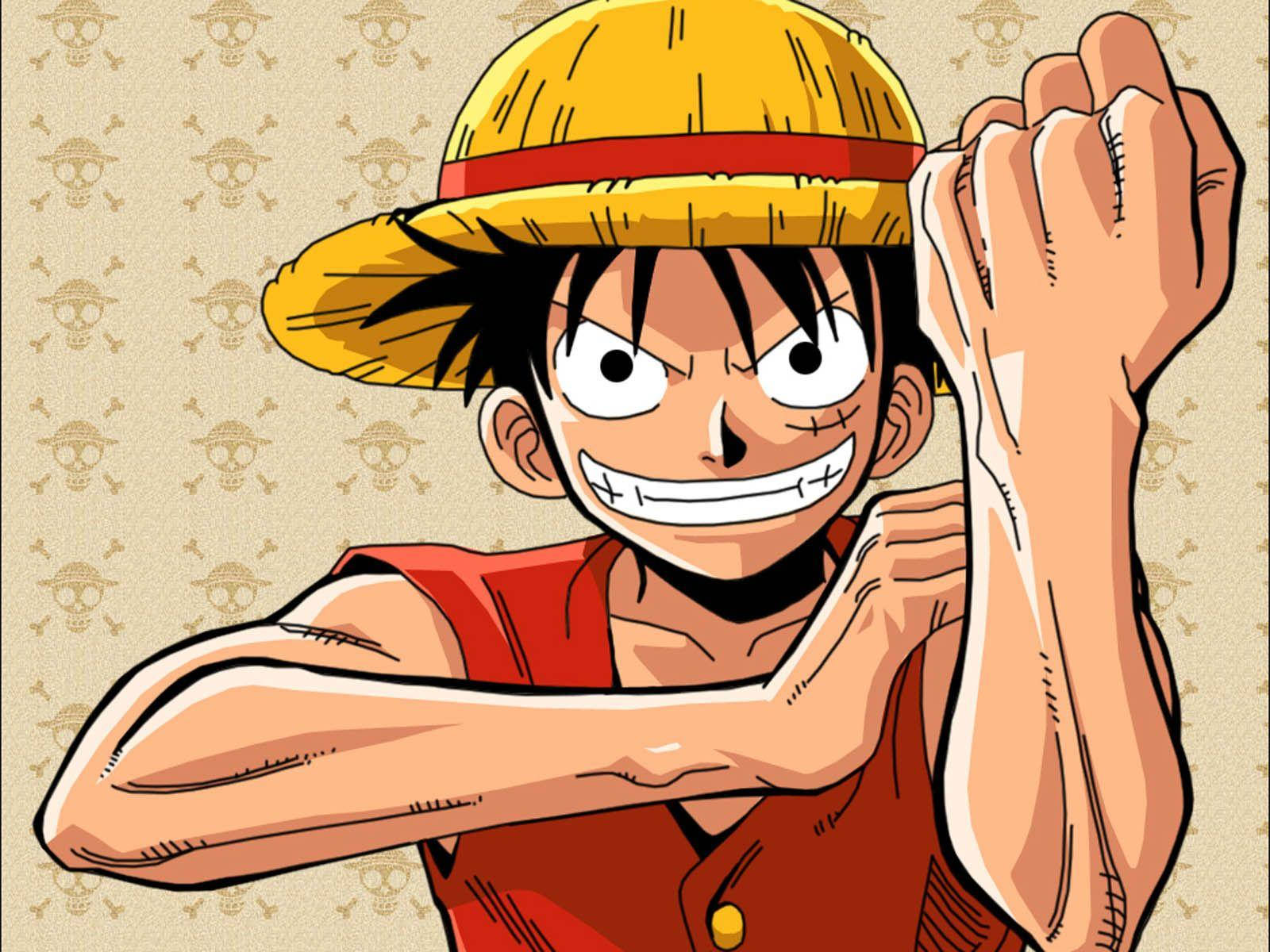Luffy 桌布 壁紙 — 一個戴草帽的決心動畫男孩，在骷髏圖案背景前露出兇猛的笑容，展示肌肉。