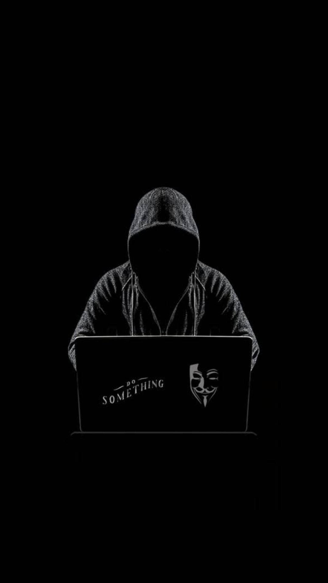Best Dark 桌布 壁紙 — 一個戴著兜帽的人坐在黑暗中，面前是一部顯示「do something」和蓋伊·福克斯面具的筆記型電腦。