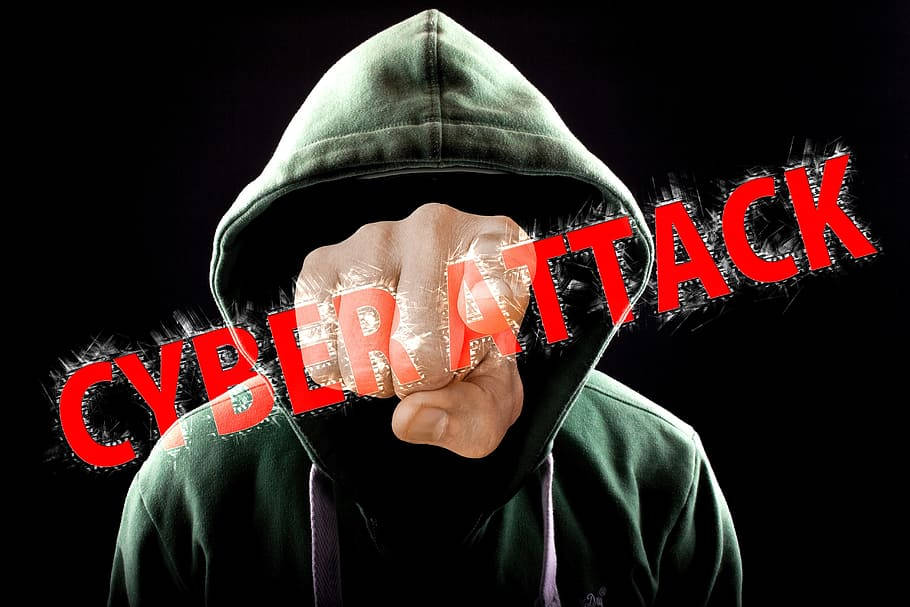 hacker 3d 桌布 壁紙 — 一個戴著兜帽的人物擊穿黑色背景上粗體紅色的「CYBER ATTACK」文字。
