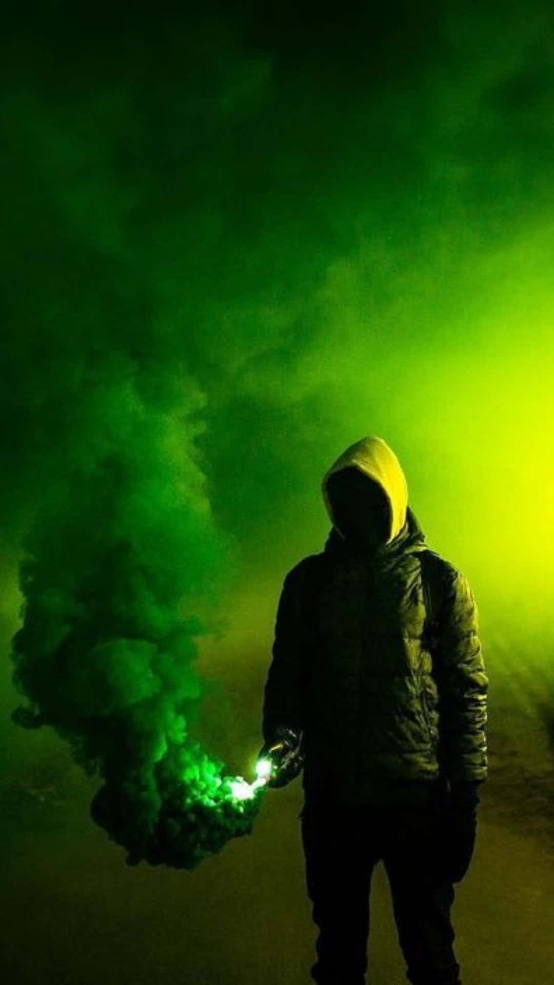 Bomb 桌布 壁紙 — 一個戴著兜帽的身影站在黑暗中，手持發出綠色光芒的照明彈，在充滿活力的綠色背景下噴出濃煙。