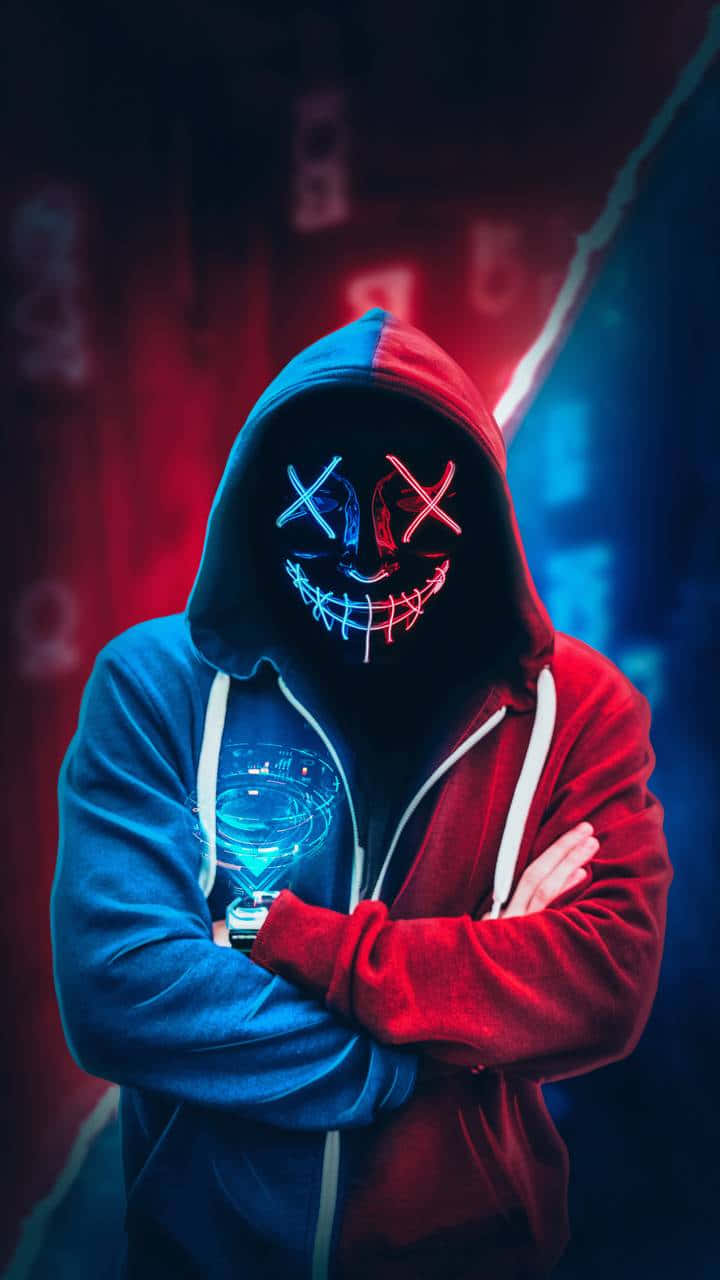 Neon Mask 桌布 壁紙 — 一個戴著分為紅色和藍色連帽衫的兜帽人物，戴著發光的霓虹面具，手持一杯藍色液體，背景黑暗帶有紅色和藍色燈光。