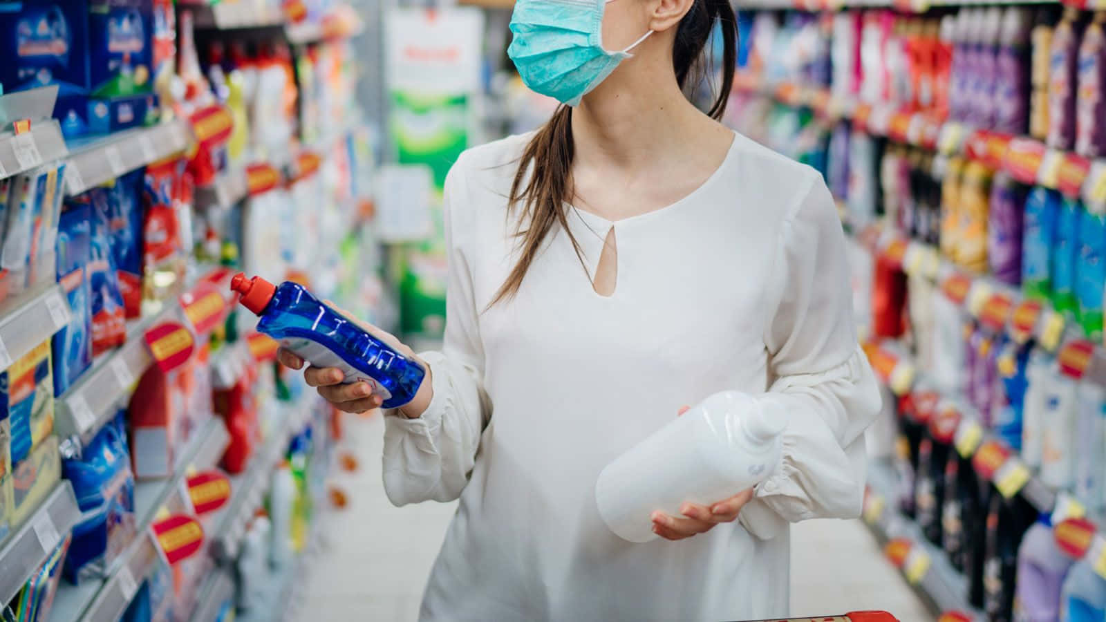Shopping 桌布 壁紙 — 一個戴著口罩的人正在光線充足的超市走道瀏覽清潔產品。