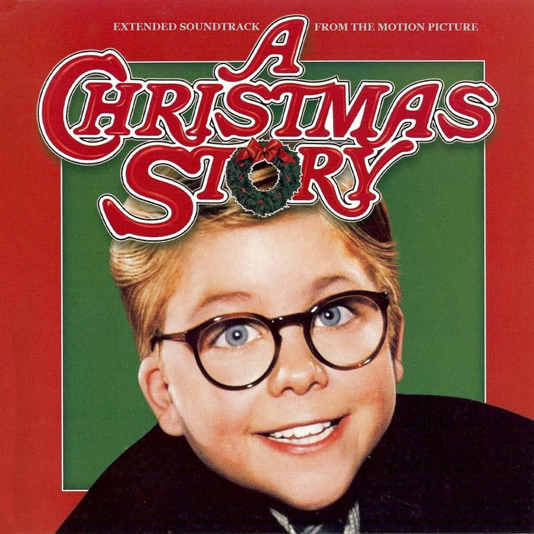 a christmas story 桌布 壁紙 — 一個戴著圓眼鏡的開朗小男孩，在節日紅綠背景前燦爛微笑，背景裝飾有節日文字和花環。