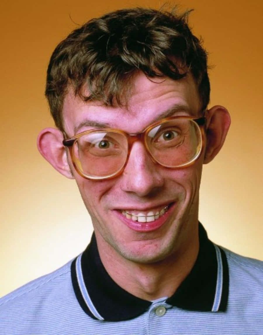 Nerd 桌布 壁紙 — 一個戴著大眼鏡、咧嘴大笑的男人，背景是溫暖的橙色。