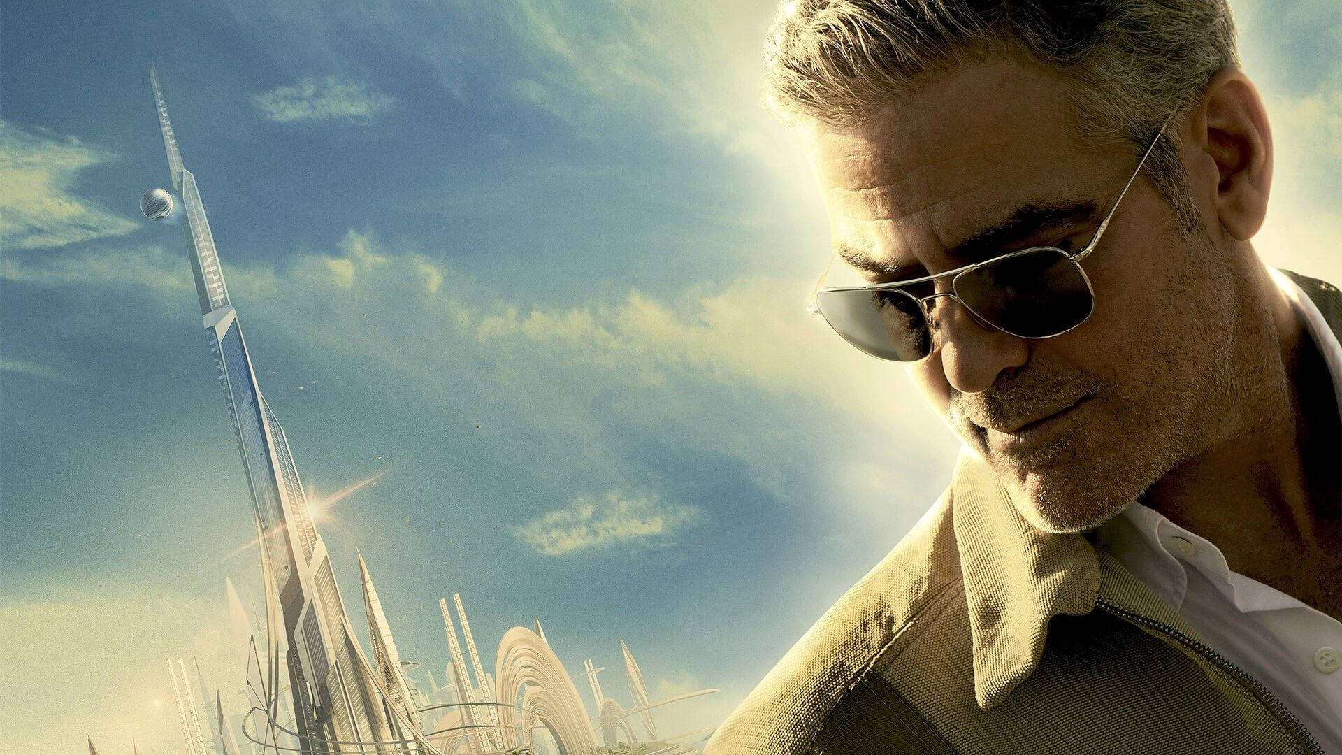 Tomorrowland Movie 桌布 壁紙 — 一個戴著太陽眼鏡的男人在明亮的藍天下，以未來主義的摩天大樓為背景，若有所思地凝視著。